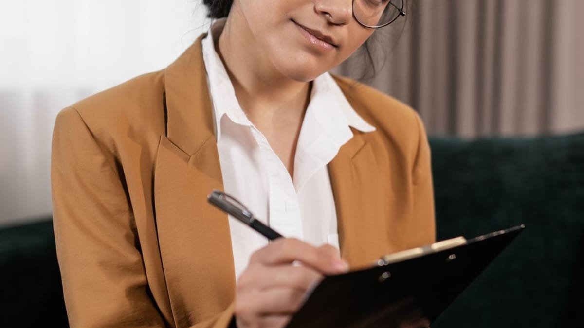 Real estate agent with a clipboard outside a home