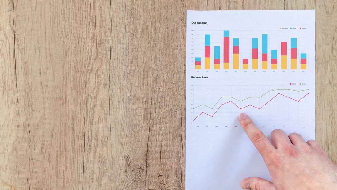 Hand reviewing a printed marketing performance chart