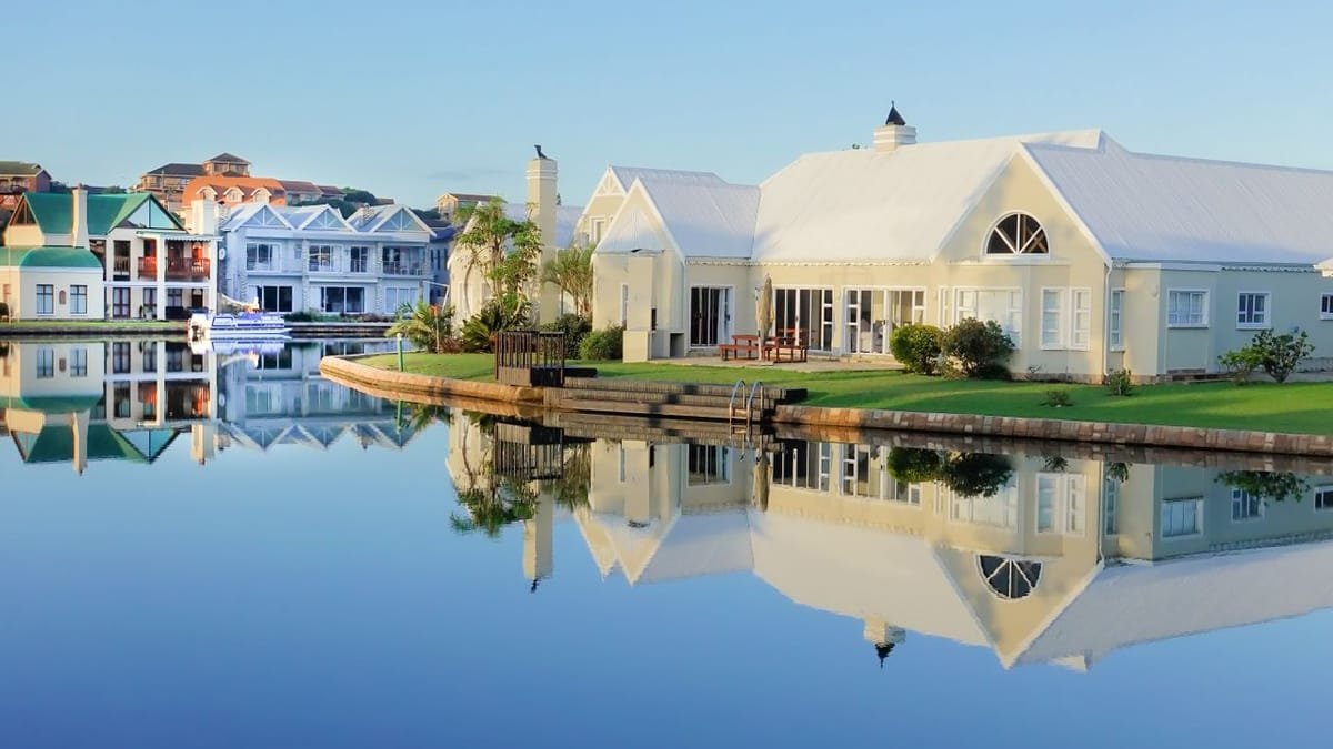 Modern luxury home reflected in water at dusk